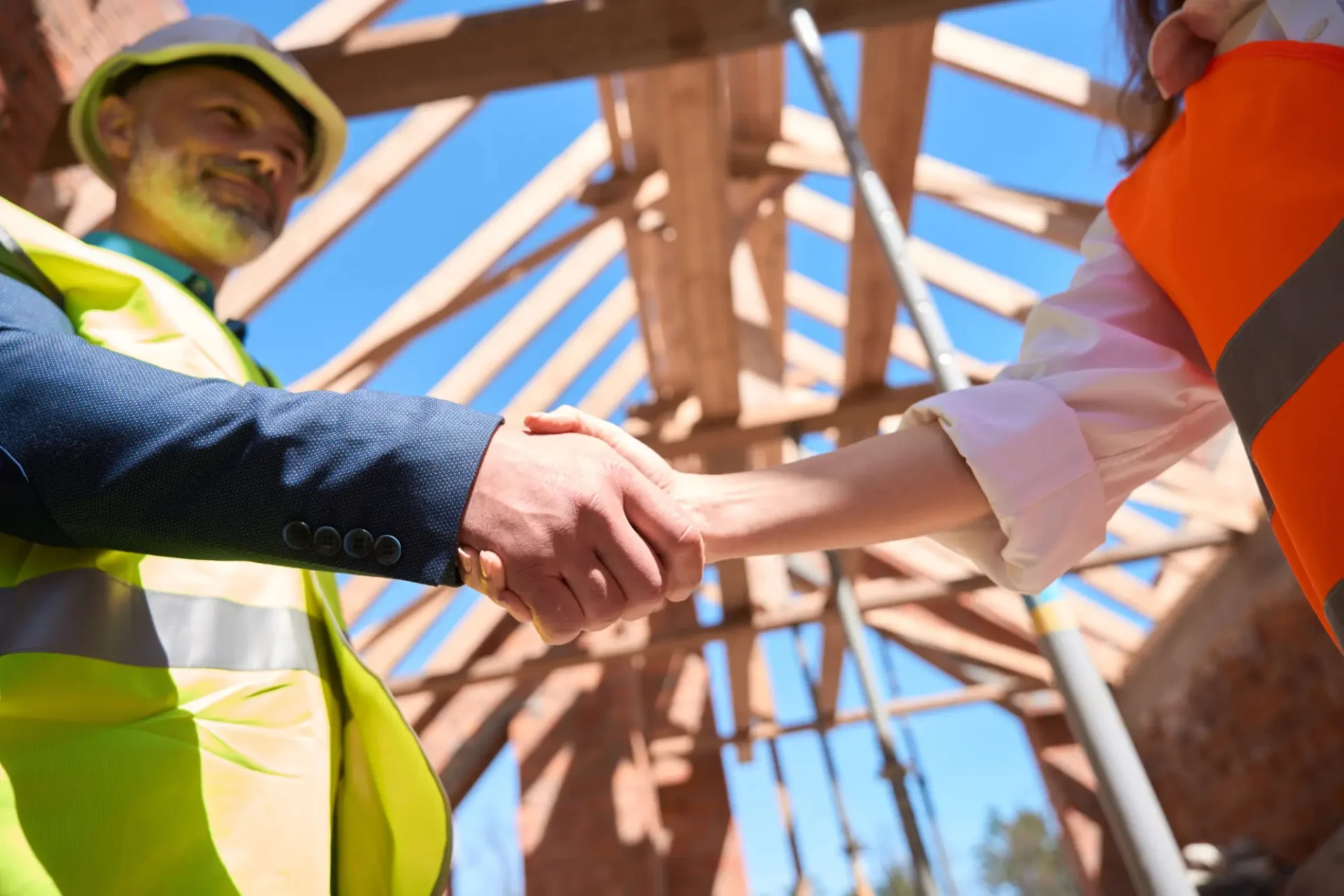 Construction workers shaking hands at site.